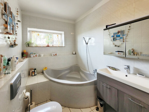 schönes Tageslichtbad mit Eckbadewanne und Dusche