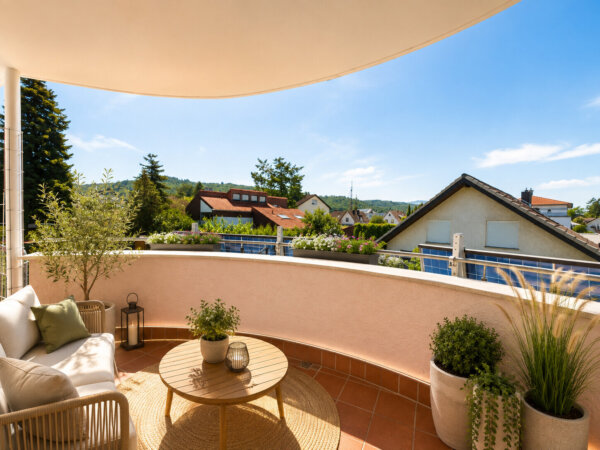 halbrunder, sonniger Balkon mit Blick in den Garten